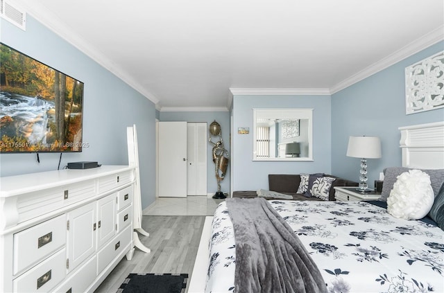 bedroom with light wood finished floors, visible vents, crown molding, and baseboards