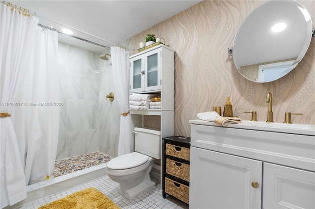 bathroom with tile patterned flooring, tiled shower, toilet, and vanity