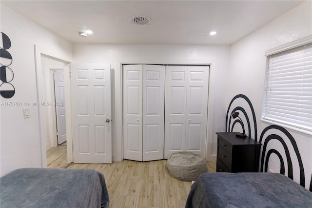 bedroom with light wood-style floors, recessed lighting, a closet, and visible vents