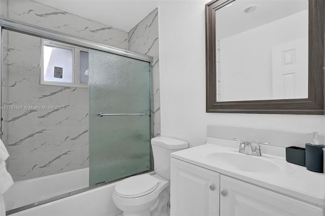 bathroom featuring toilet, shower / bath combination with glass door, and vanity