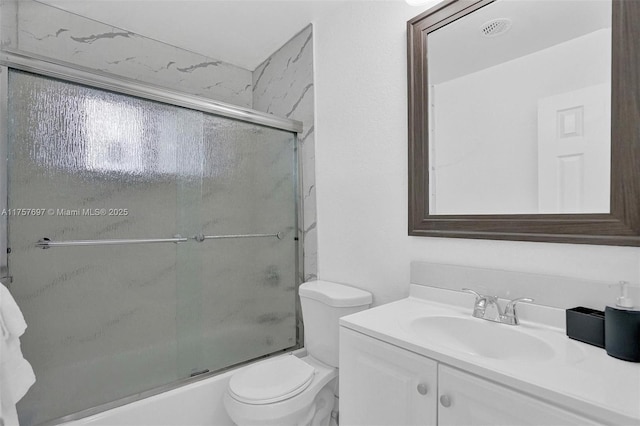 full bathroom with bath / shower combo with glass door, vanity, and toilet