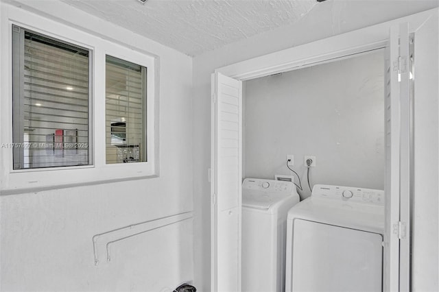 laundry area featuring laundry area, a textured ceiling, and washing machine and clothes dryer