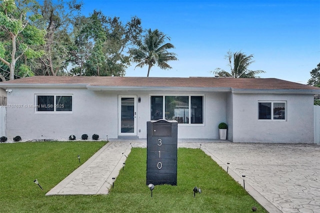 ranch-style home featuring stucco siding and a front yard