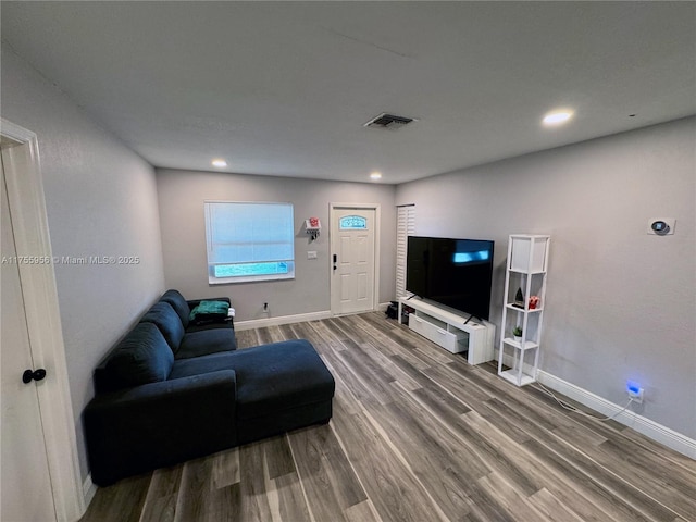 living area with recessed lighting, visible vents, baseboards, and wood finished floors