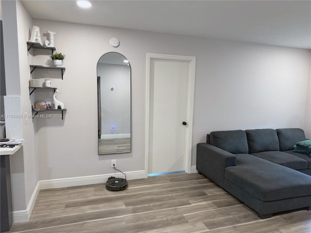 living room featuring recessed lighting, baseboards, and wood finished floors