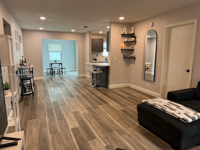 living room with recessed lighting, baseboards, and dark wood-style flooring