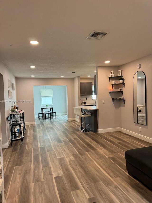 living area featuring recessed lighting, visible vents, baseboards, and dark wood-type flooring