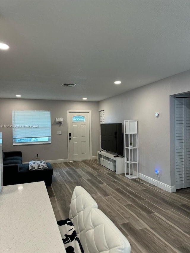 living area with visible vents, recessed lighting, baseboards, and wood finished floors