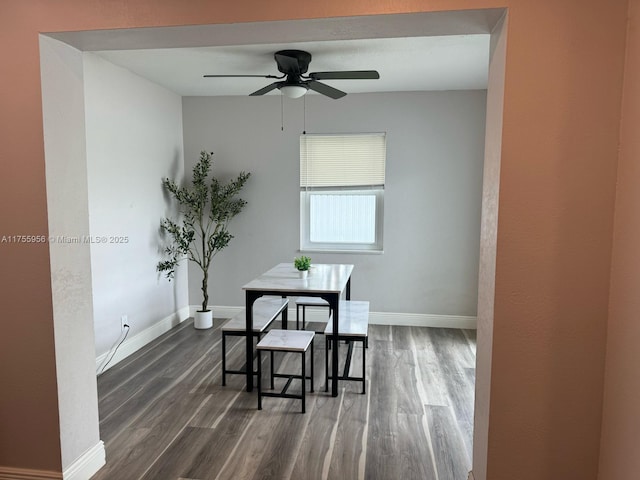 dining area featuring dark wood-style floors, a ceiling fan, and baseboards