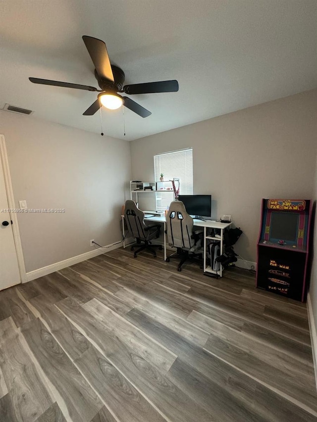 office area with visible vents, a ceiling fan, baseboards, and wood finished floors