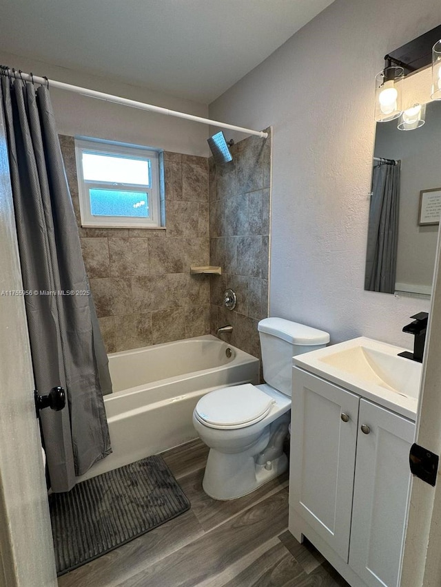 bathroom featuring vanity, toilet, wood finished floors, and shower / tub combo with curtain