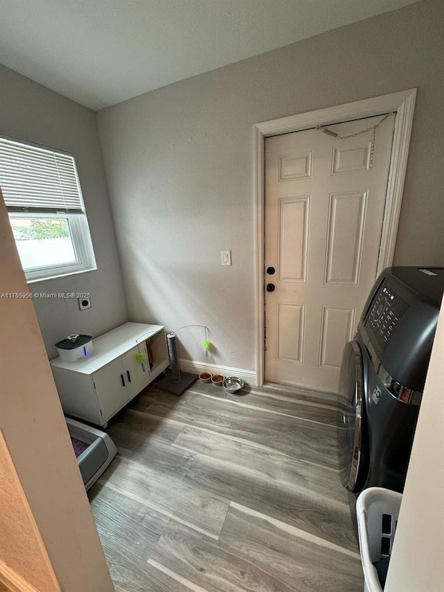 laundry room featuring laundry area, wood finished floors, and baseboards