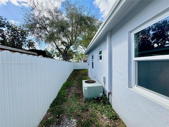 view of property exterior featuring cooling unit, a fenced backyard, and stucco siding