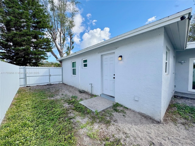 back of house with crawl space, stucco siding, and a fenced backyard