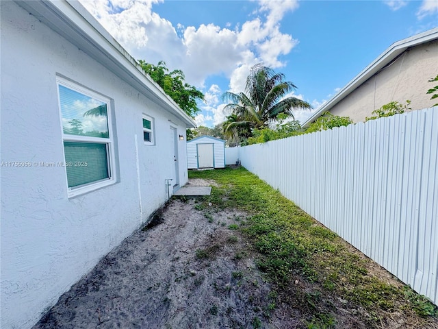 view of yard featuring an outbuilding, a storage shed, and fence private yard