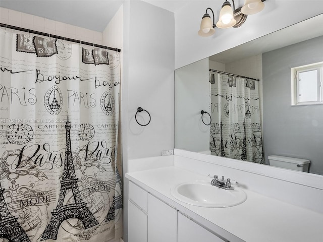 bathroom featuring a chandelier, toilet, vanity, and curtained shower