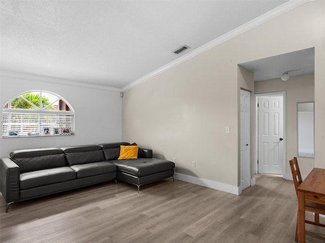 living area with baseboards, crown molding, visible vents, and wood finished floors