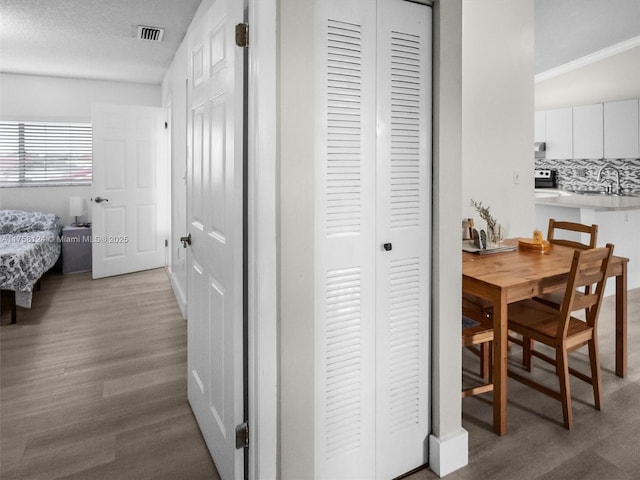 hallway with visible vents and wood finished floors