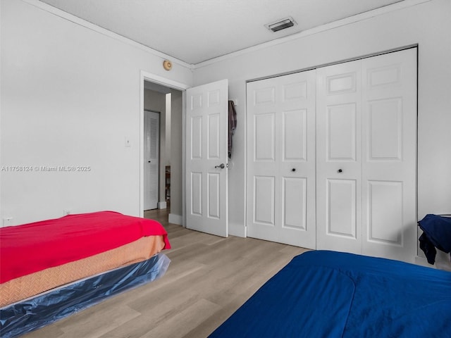 bedroom featuring a closet, wood finished floors, and visible vents