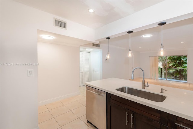 kitchen featuring decorative light fixtures, light countertops, visible vents, stainless steel dishwasher, and a sink