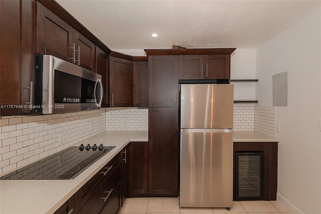 kitchen featuring stainless steel appliances, light countertops, dark brown cabinets, and light tile patterned floors