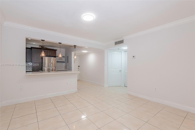 spare room with baseboards, light tile patterned floors, visible vents, and crown molding