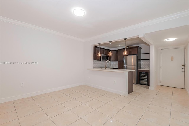 kitchen featuring a peninsula, light countertops, appliances with stainless steel finishes, tasteful backsplash, and crown molding