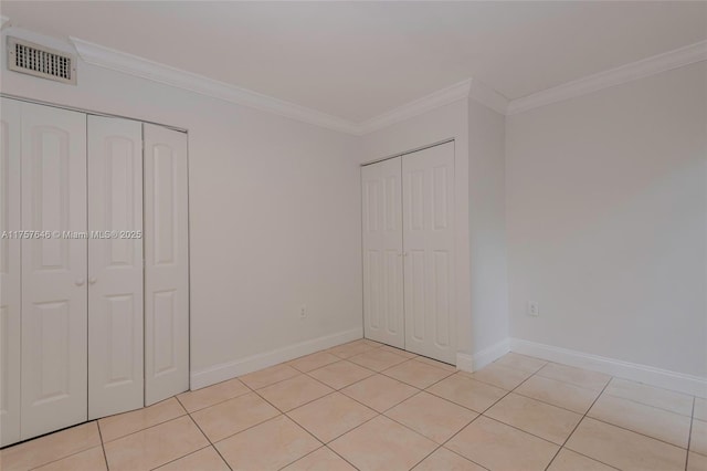 unfurnished bedroom featuring light tile patterned flooring, visible vents, and ornamental molding