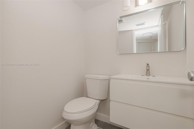 bathroom with visible vents, baseboards, vanity, and toilet