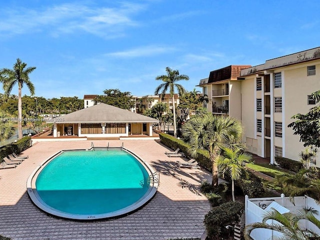 pool with a patio and fence