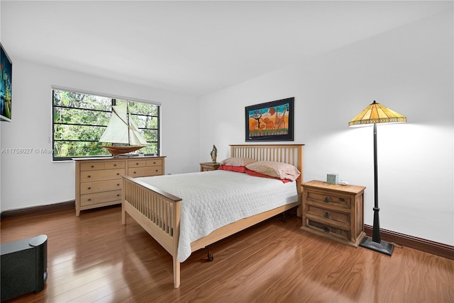 bedroom featuring baseboards and wood finished floors