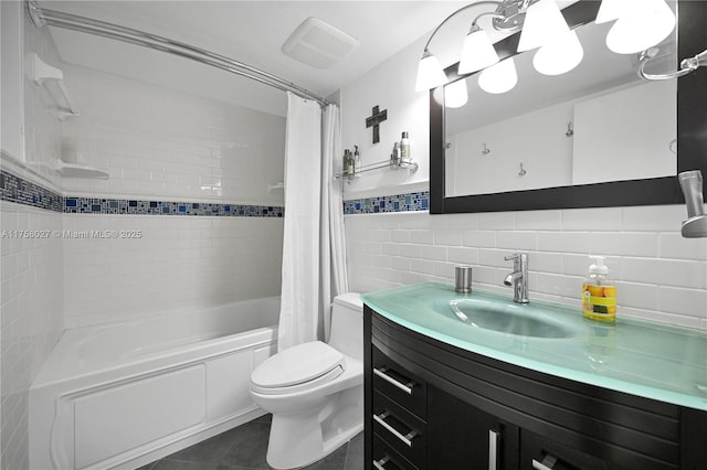 bathroom with toilet, shower / tub combo with curtain, tile patterned flooring, vanity, and tile walls