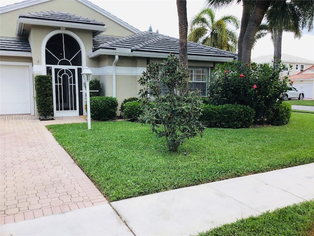 view of front facade with a tile roof, a front lawn, and stucco siding