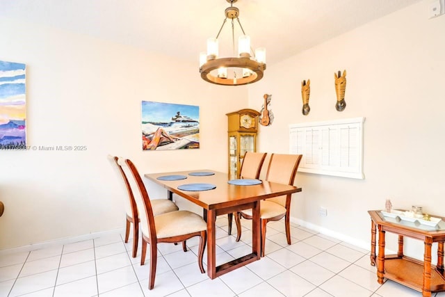 dining area featuring baseboards, light tile patterned flooring, and an inviting chandelier