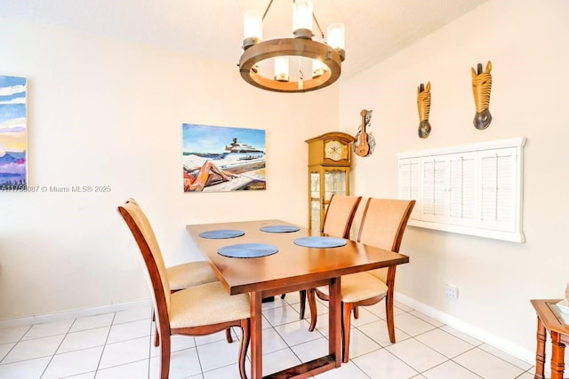 dining room with light tile patterned flooring, a notable chandelier, and baseboards