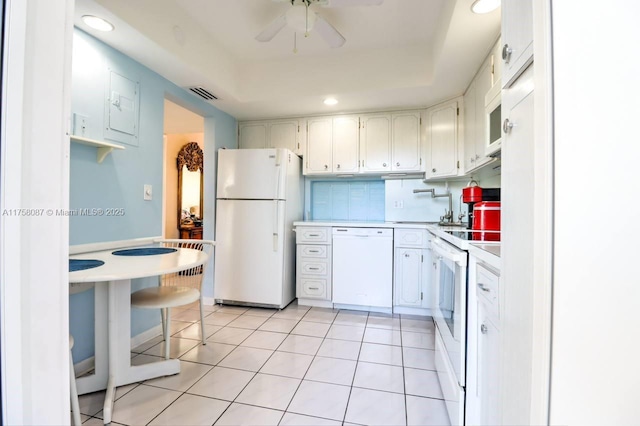 kitchen featuring light tile patterned floors, tasteful backsplash, light countertops, white cabinetry, and white appliances