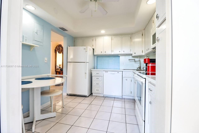 850 NE 12th Ave Unit 210, Hallandale Beach, FL 33009 - kitchen with light countertops, a tray ceiling, white appliances, light tile patterned floors, and decorative backsplash