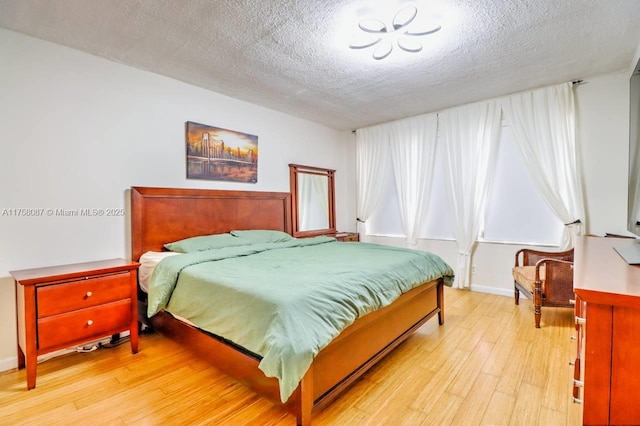 850 NE 12th Ave Unit 210, Hallandale Beach, FL 33009 - bedroom with baseboards, a textured ceiling, and light wood finished floors