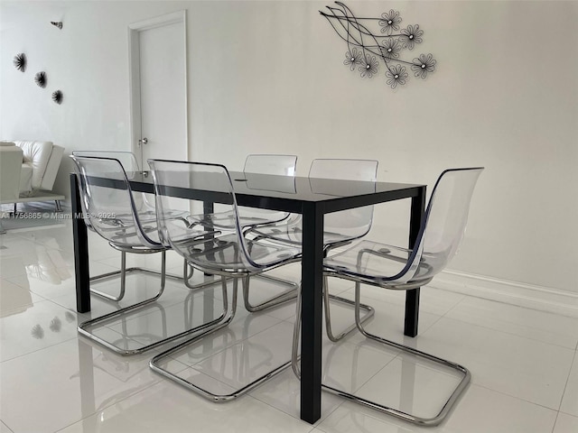 dining area with baseboards and tile patterned floors