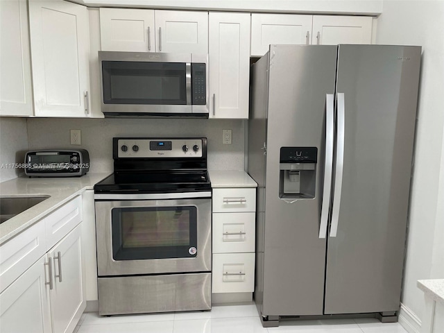 kitchen featuring light countertops, appliances with stainless steel finishes, and white cabinets