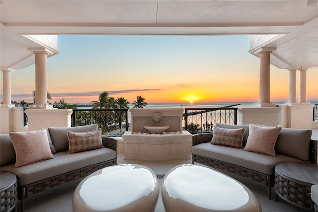 patio terrace at dusk with an outdoor living space and a balcony