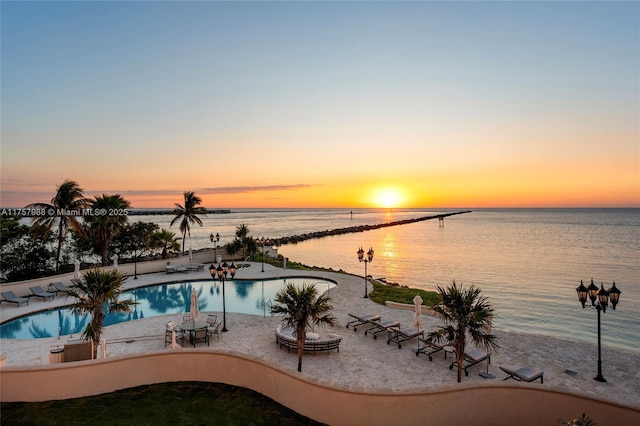 pool featuring a patio area and a water view