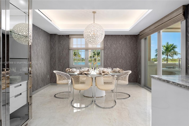 dining room featuring wallpapered walls, plenty of natural light, and a raised ceiling