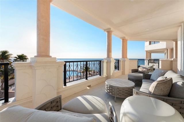 balcony featuring a water view and an outdoor living space