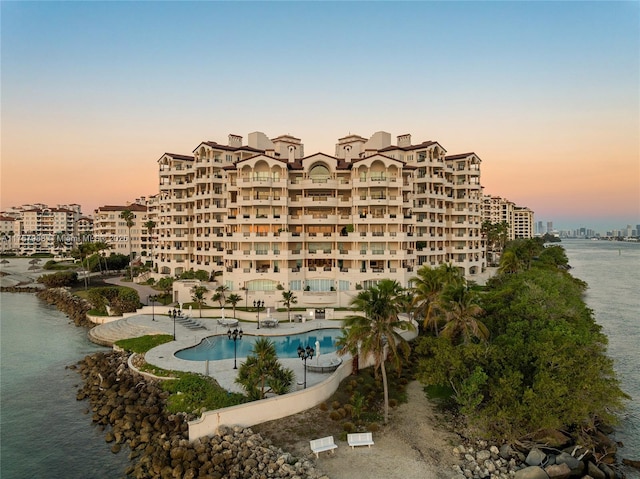 view of property with a water view, a city view, and a community pool