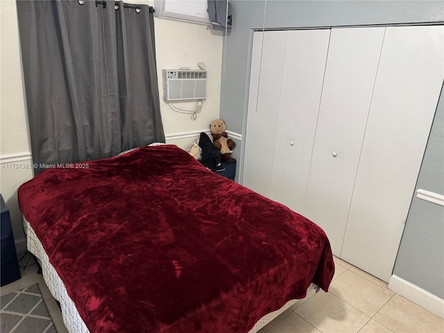 bedroom with a closet, a wall unit AC, and light tile patterned floors