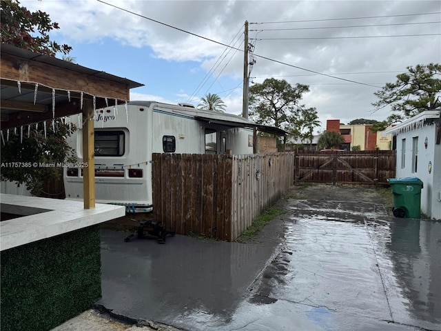 view of side of home featuring fence and a gate