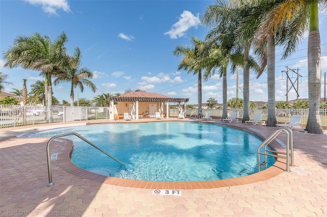 pool with a patio area and fence