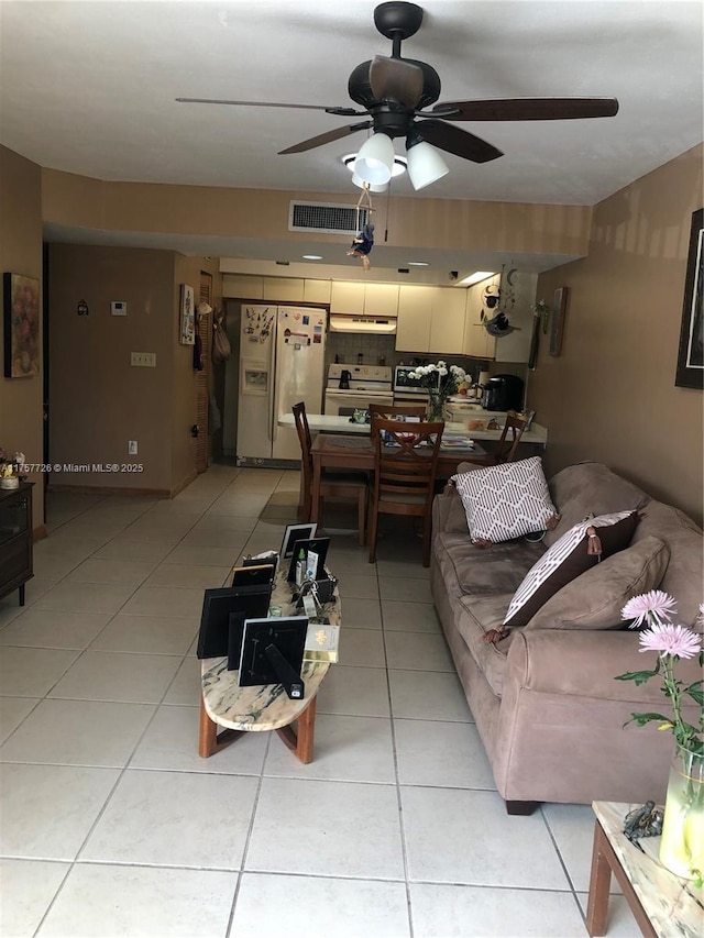 living area with light tile patterned floors, ceiling fan, and visible vents