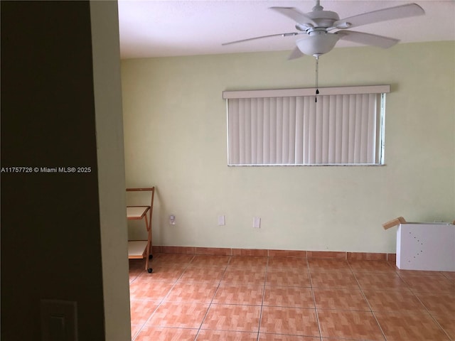 tiled empty room featuring a ceiling fan